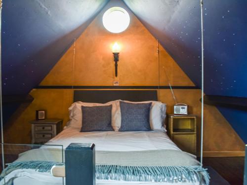 1 dormitorio con 1 cama con techo triangular en The Sunday Schoolroom en Wootton Glanville