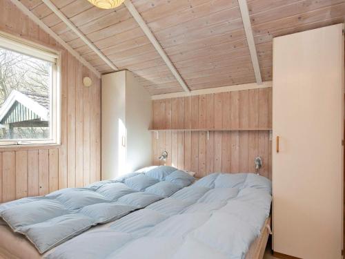 ein großes Bett in einem Zimmer mit Fenster in der Unterkunft Three-Bedroom Holiday home in Humble 2 in Humble