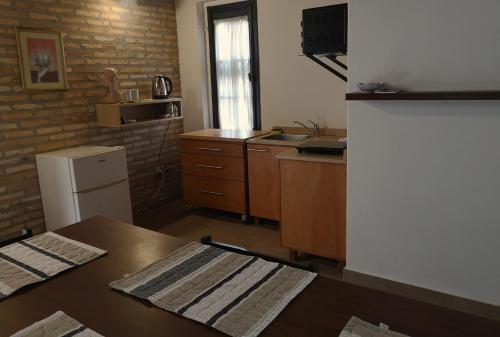 a small kitchen with a table and a refrigerator at Violeta Roga in Asuncion