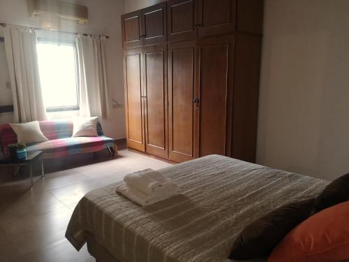 1 dormitorio con 1 cama, armario y silla en Violeta Roga en Asunción