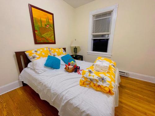 a bedroom with a bed with yellow and blue pillows at Home sweet home in the heart of Wilmington. in Wilmington