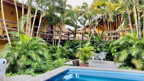 a resort with a swimming pool and palm trees at Pousada Refugium in Itacaré