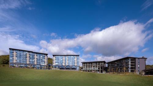 a group of buildings with a green field in front at Park Hyatt Niseko Hanazono in Kutchan