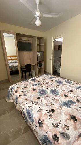 a bedroom with a bed with a floral bedspread at La Posada de Pepe in Piura