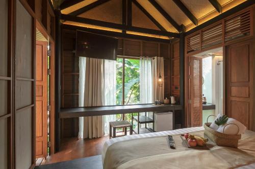 ein Schlafzimmer mit einem Bett in einem Zimmer mit einem Fenster in der Unterkunft The Spa Resorts - Lamai Village in Nathon Bay