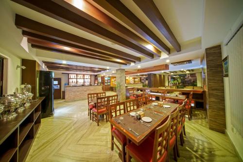 restauracja z drewnianymi stołami i krzesłami oraz bar w obiekcie Kumari Star Inn w mieście Pokhara