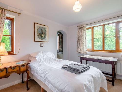 拉尼德洛伊斯的住宿－Cwmfron House，卧室配有一张床、一张书桌和窗户。