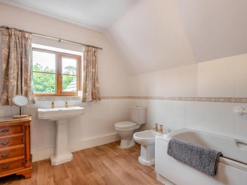 a bathroom with a tub and a toilet and a sink at Cwmfron House in Llanidloes