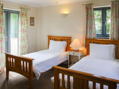 a bedroom with two beds and a window at Willows Barn in Clenchwarton