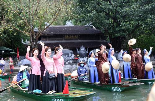a group of women standing in boats in the water at Ninh Binh Brother's Homestay in Ninh Binh