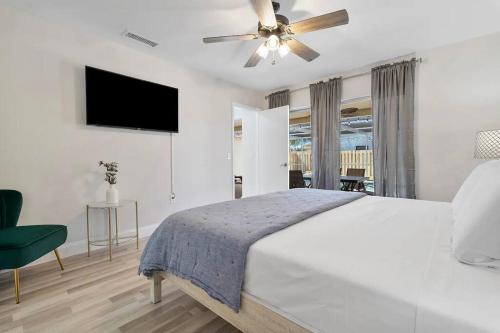 una camera da letto bianca con un letto e un ventilatore a soffitto di Beautiful & Peaceful 4 Bedroom Home With a Pool a Sunrise