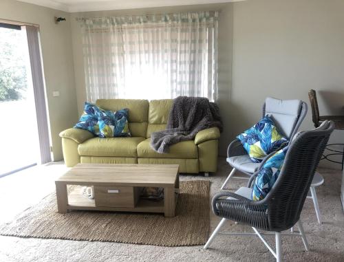 a living room with a couch and two chairs at Renas Court, Unit 6, 72 Little Street in Forster