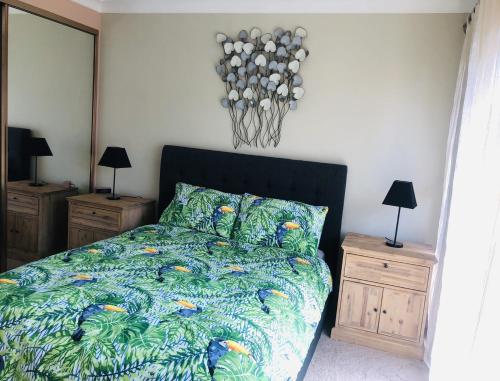 a bedroom with a bed and two night stands with lamps at Renas Court, Unit 6, 72 Little Street in Forster