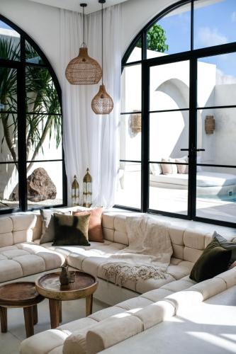 a living room with a white couch and large windows at Mahi Mahi Villa & Suites in Uluwatu