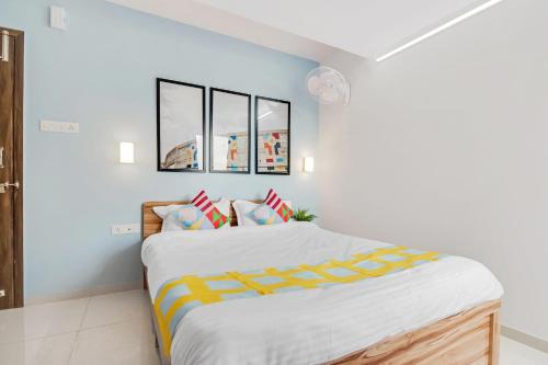 een slaapkamer met een groot bed met twee foto's aan de muur bij OYO Home Hotel Fort Inn Near Golconda Fort in Haidar Sāhibgūda