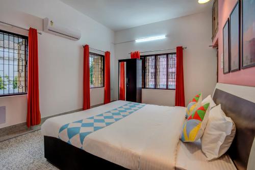 a bedroom with a large bed with red windows at OYO Home Jaam's Home Stay in Bhubaneshwar