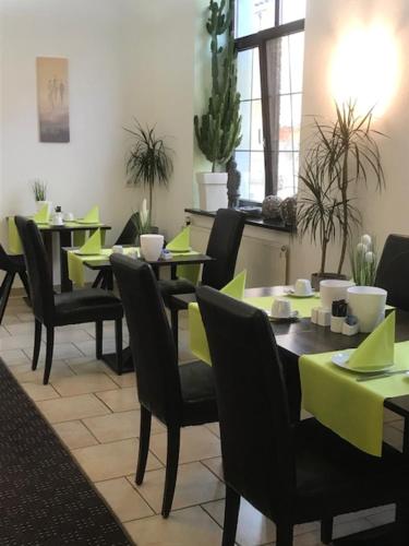Hotel Augsburg Goldener Falke في اوغسبورغ: غرفة طعام مع طاولات وكراسي مع طاولات خضراء الليمون