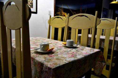 una mesa con dos sillas y dos tazas de mano en el Hotel Danubio de Villa Gesell