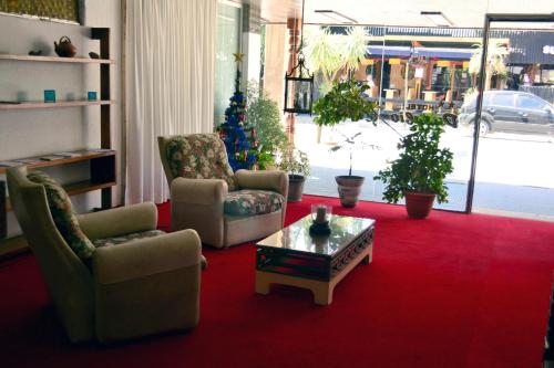 sala de estar con 2 sillas y mesa de centro en Hotel Danubio en Villa Gesell