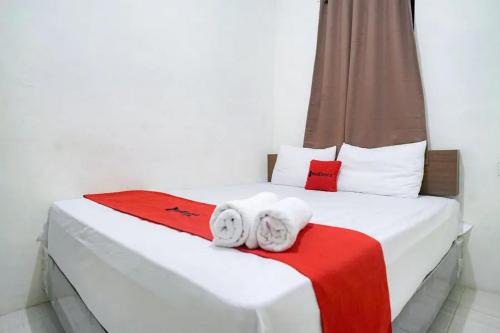 a bedroom with a bed with towels on it at RedDoorz near Ekowisata Mangrove Belawan in Belawan