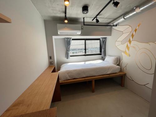 een kleine slaapkamer met een bed en een raam bij ART HOTELS SHIBUYA in Tokyo