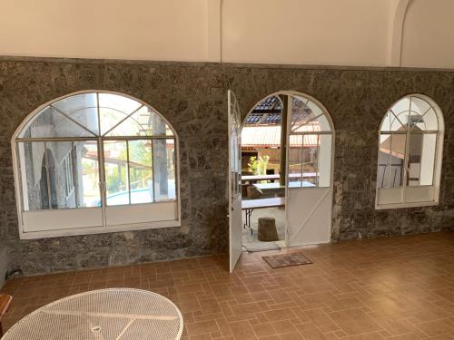a room with two arched windows and a door at Posada Quetzalin in Cuetzalán del Progreso