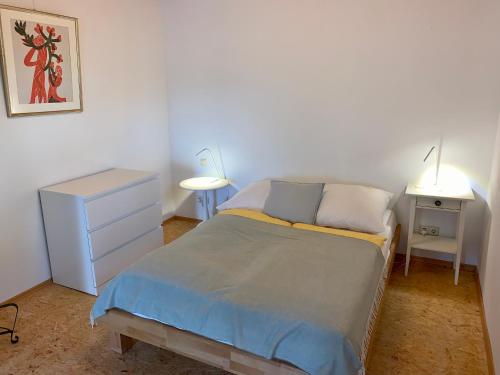 - une chambre avec un lit, une commode et une lampe dans l'établissement Schöne Wohnung in der Nähe von Schwäbisch Hall, à Rieden