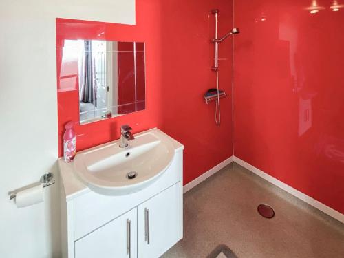 baño rojo con lavabo y ducha en Thistle Dew en Great Yarmouth