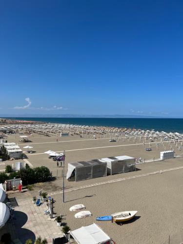 マルゲリータ・ディ・サヴォイアにあるAl delfino bluのたくさんのテントがたくさんの人が集まる浜
