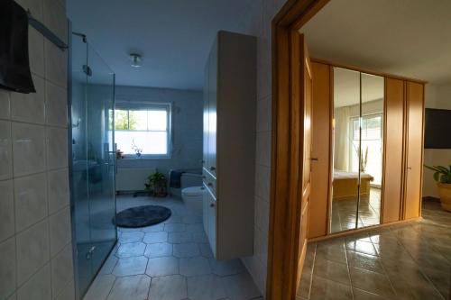 a bathroom with a shower and a toilet and a glass door at Schönes & gemütliches Ferienhaus nahe der Nordsee in Schortens