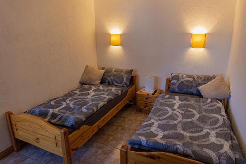 two beds in a room with lights on the wall at Schönes & gemütliches Ferienhaus nahe der Nordsee in Schortens