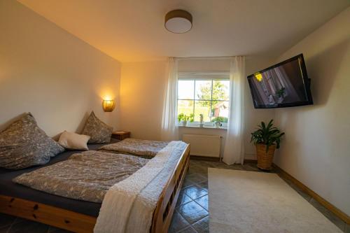 1 dormitorio con 2 camas y TV de pantalla plana en Schönes & gemütliches Ferienhaus nahe der Nordsee en Schortens