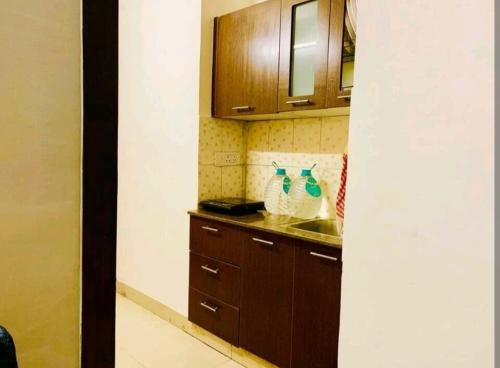 a kitchen with wooden cabinets and a sink and a counter at Aloha Serenity Apartments in Rishīkesh