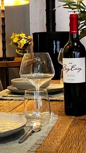 a bottle of wine and a glass on a table at La Plonploniere in Aix-en-Issart