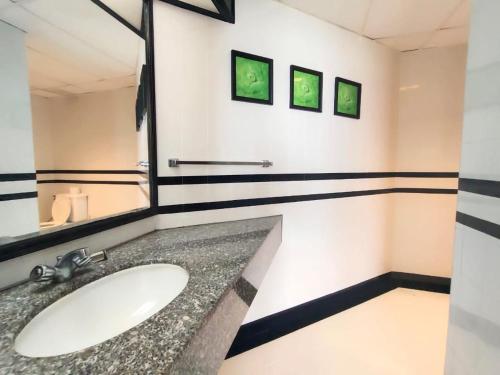 a bathroom with a sink and a mirror at Seaview Suite at Rainbow Paradise in Tanjung Bungah