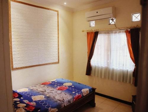 a small bedroom with a bed and a window at Guest House Dissa in Purwokerto
