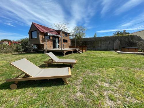 a backyard with two picnic tables and a tiny house at myinsolite - Tiny-house, jacuzzi, brasero, piscine in Aigues-Mortes