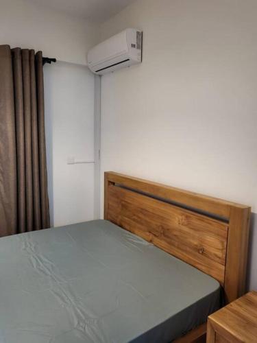 een kleine slaapkamer met een bed en airconditioning bij Elegant 1-bedroom apartment with close amenities in Quatre Bornes