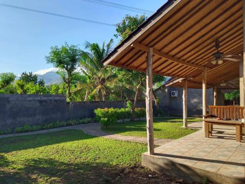 a wooden pavilion with a picnic table in a yard at Menjangan View in Banyuwedang