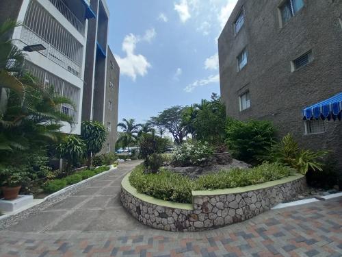 a walkway in front of a building with plants at Crystoural Apartment Liguanea Sovereign Apt - 2 Bedrooms, 3 Beds, Host 4 Guest- Kingston! in Kingston