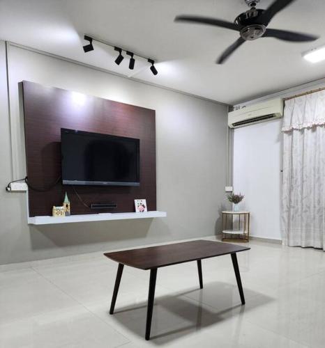 a living room with a table and a flat screen tv at Welcome,3R2B Cheerful Family's Homestays Sandakan. in Sandakan