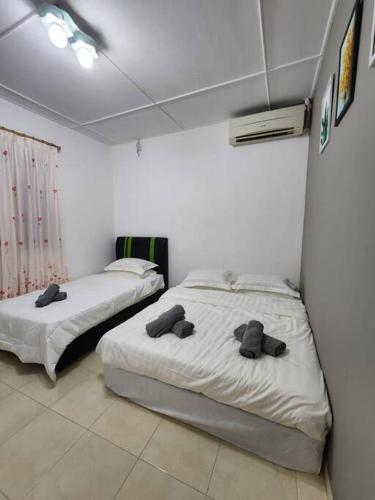 two beds in a room with at Welcome,3R2B Cheerful Family's Homestays Sandakan. in Sandakan