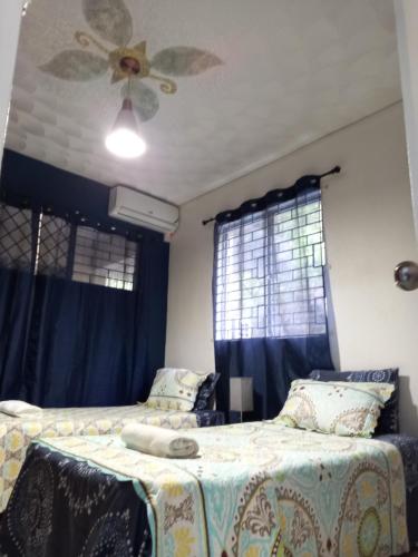 a bedroom with two beds and a ceiling fan at Crystoural Apartment Liguanea Sovereign Apt - 2 Bedrooms, 3 Beds, Host 4 Guest- Kingston! in Kingston