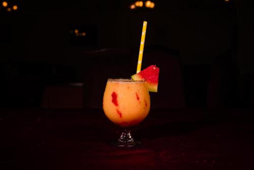 a drink with a piece of fruit in a glass at La-Paz Gardens Beacon Hotel - Vasco da Gama Goa in Vasco Da Gama