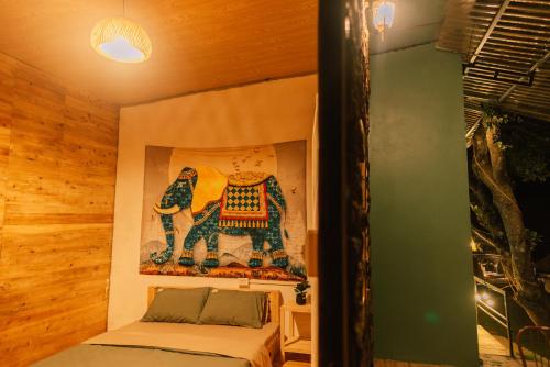a room with a bed and a painting on the wall at Lacasa home&coffee Mộc Châu in Mộc Châu