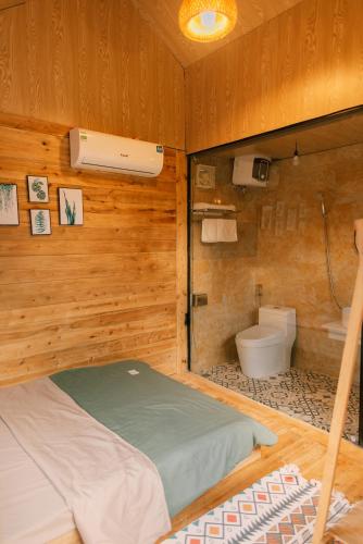 a room with a bed and a toilet in it at Lacasa home&coffee Mộc Châu in Mộc Châu