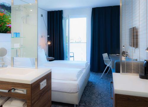 a hotel room with two beds and a desk at Dorint Hotel Düren in Düren - Eifel