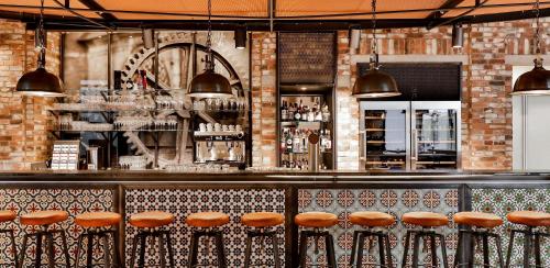 a bar with orange stools in a restaurant at Dorint Hotel Düren in Düren - Eifel