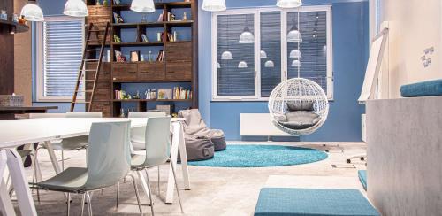 デューレン・アイフェルにあるDorint Hotel Dürenの青い壁の客室で、テーブルと椅子が備わります。