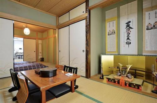 a dining room with a wooden table and chairs at Guest House TIHARU 6bedrooms12people max and Straight to USJ and Near the hot spring in Osaka